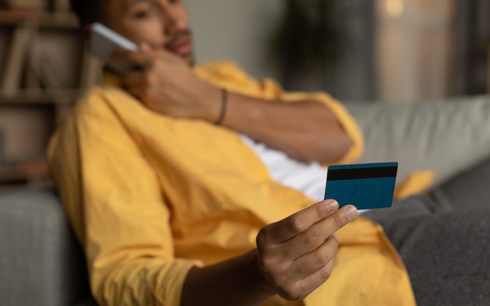 A shopper with a payment card calling their bank about a disputed payment